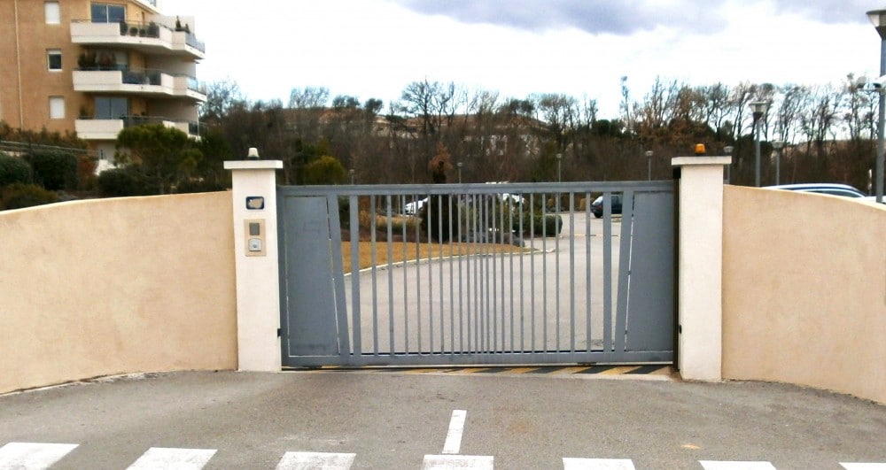 Portail coulissant en fer à barreaux inégaux et tôle